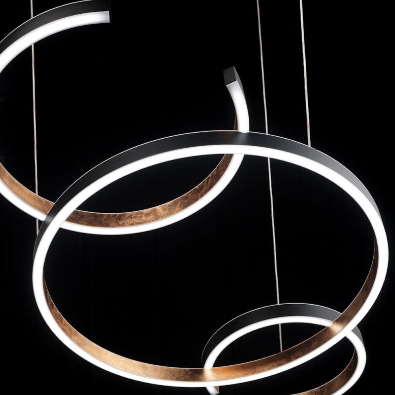 Hug pendant lamp with 3 connected rings outside black, inside copper leaf